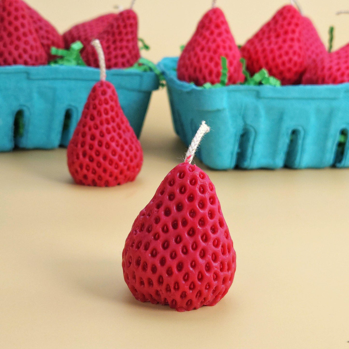 A realistic basket of strawberry candles, strawberry set candle, blue pulp basket of strawberries, red strawberry with wick on yellow background, green crinkle cut paper inside, gift of cake topper, birthday strawberry topper, berry with holes, looks like real strawberry, birthday candles, home decor, kitchen decor candles, giving off a sweet strawberry scent, juicy strawberry, strawberry-shaped soy candles