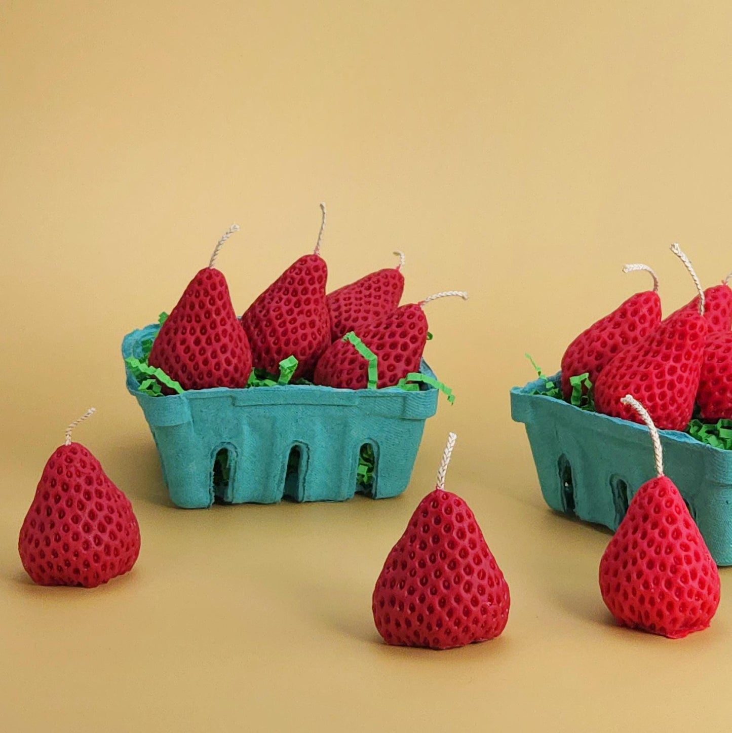 A realistic basket of strawberry candles, strawberry set candle, blue pulp basket of strawberries, red strawberry with wick on yellow background, green crinkle cut paper inside, gift of cake topper, birthday strawberry topper, berry with holes, looks like real strawberry, birthday candles, home decor, kitchen decor candles, giving off a sweet strawberry scent, juicy strawberry, strawberry-shaped soy candles