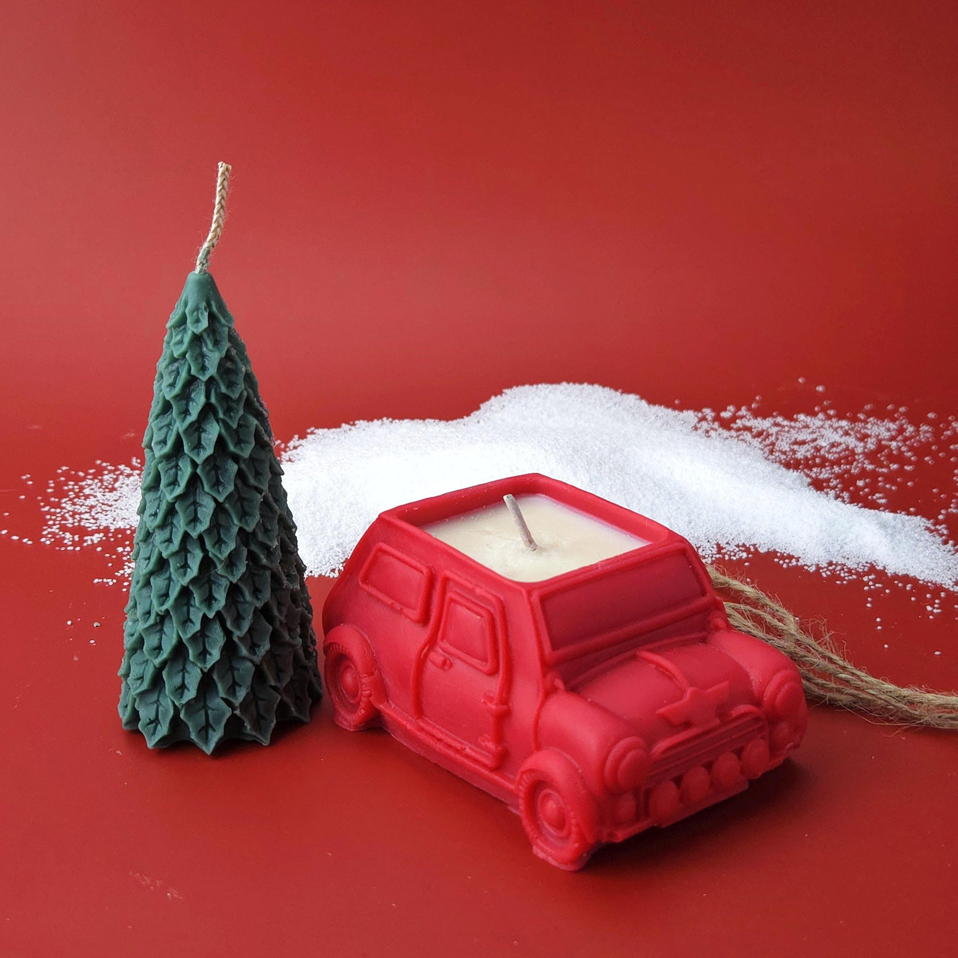 Two-piece Christmas candle set featuring a red car candle and detachable Christmas tree candle tied together with twine.